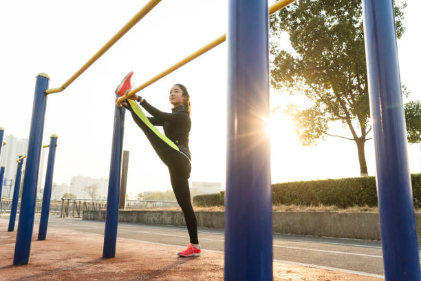 istock female athlete stretching her legs on horizontal bar 908933082