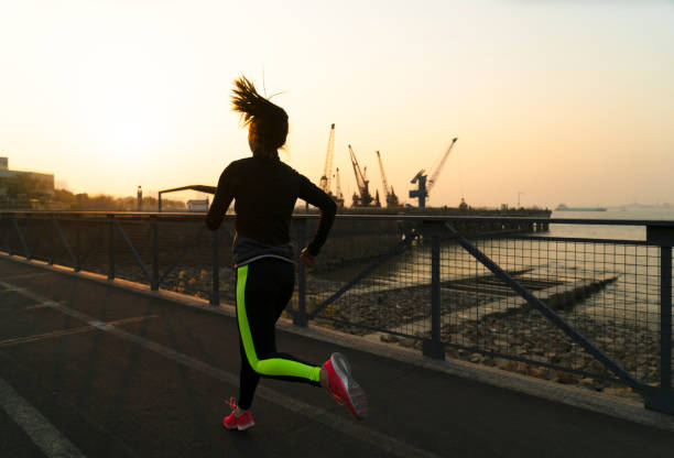 istock young female running against twilight sky 908936866