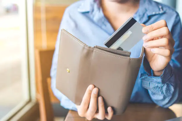 Women's hand Using a credit card, she pulled the card out of her wallet.