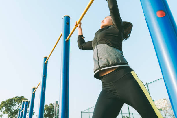 istock young woman hanging on horizontal bar 908940084
