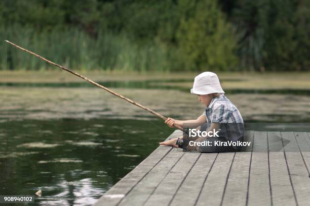 Little Boy With Oldfashioned Fishing Rod On A Wooden Pier Stock Photo - Download Image Now