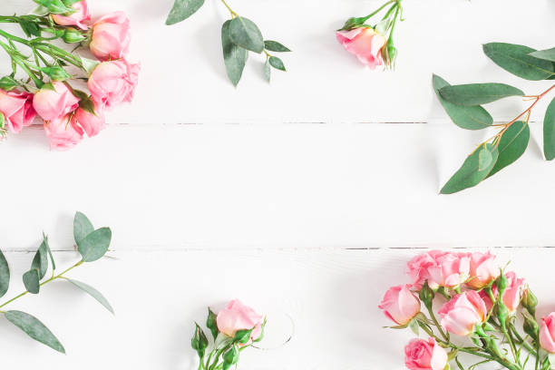 istock Eucalyptus branches and pink rose flowers. Flat lay, top view 908940554