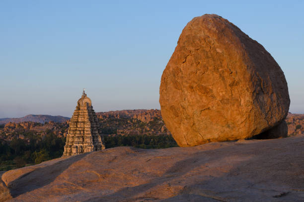 istock Boulder and temple in Hampi, India 908944248