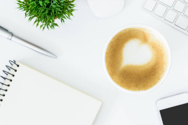 istock A latte coffee with art heart milk on the white desk table from top view and copy space. Flat lay with desk, business and valentine concept. 908949536