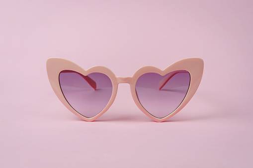 Pink heart shape sunglasses isolated on pink background