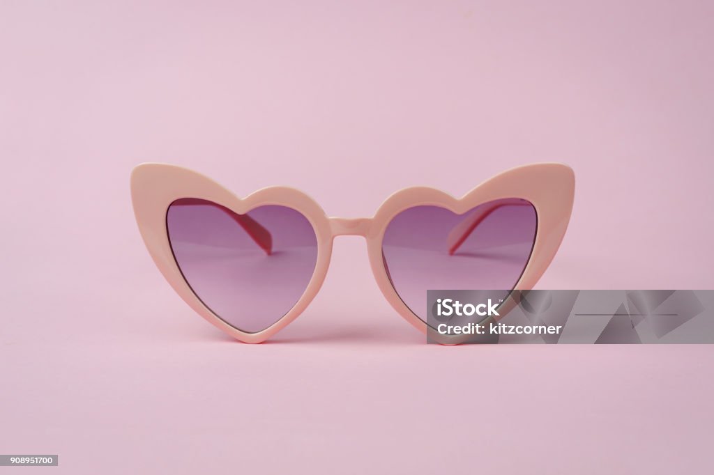 Pink heart shape sunglasses isolated Pink heart shape sunglasses isolated on pink background Eyeglasses Stock Photo