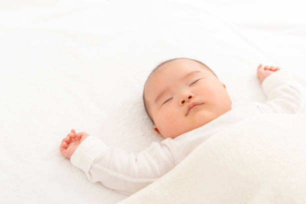 baby sleeping in bed - baby lying down sleeping asian ethnicity imagens e fotografias de stock