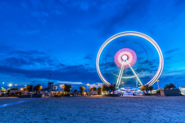 ruota panoramica rotante all'alba ora blu a rimini, italia. immagine astratta a lunga esposizione - rimini foto e immagini stock