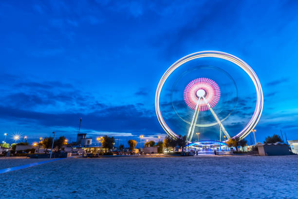 Spinning ferris wheel at sunrise blue hour in Rimini, Italy. Long exposure abstract image Spinning ferris wheel at sunrise blue hour in Rimini, Italy. Long exposure abstract image. rimini stock pictures, royalty-free photos & images