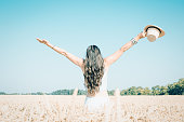 Young woman having fun in wheat field