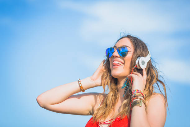 istock Young woman  having fun outdoors, enjoying music, drinking beer 908960130