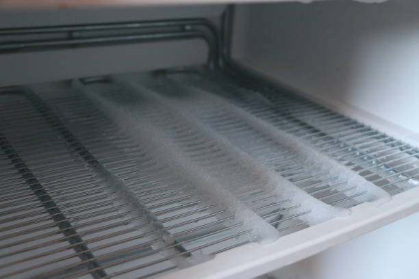 istock freezer compartment with an open door. The freezer covered with snow and ice is open for defrosting. In the refrigerator, snow and ice are melting, frozen on the walls and shelves. 908963368