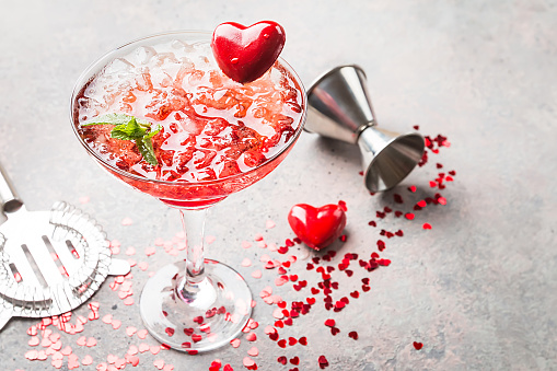 Fresh red margarita cocktail with hearts over gray background, valentine day concepts