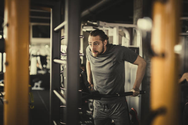istock Young athletic man doing strength exercises in a gym. 908963982