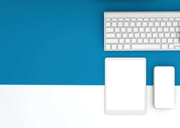 Aerial view of digital tablet, smart phone and computer keyboard over blue background.