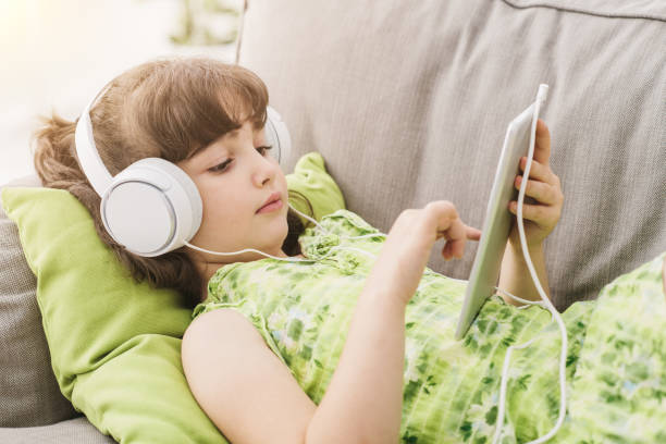 istock Cute girl relaxing on the sofa and using a tablet 908965978