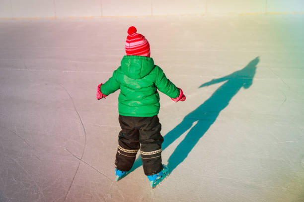 istock little girl learning to skate in winter 908968460