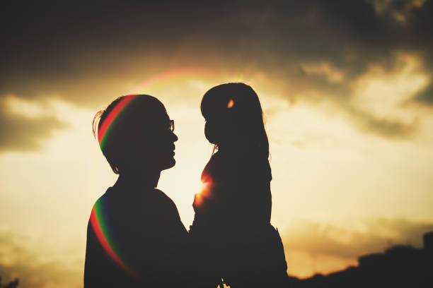 istock Father and little daughter silhouettes at sunset 908969754