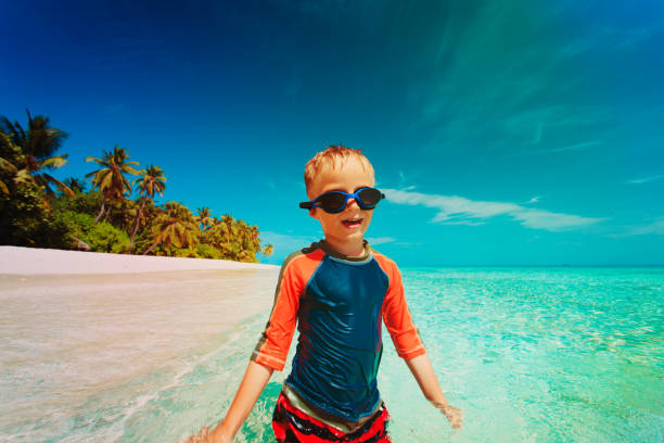 istock little boy swim play with water on beach 908974172