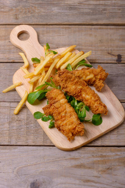 istock Fried strips chicken breast with french fries and greenery 908974500