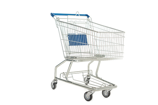 Shopping cart full of fresh vegetables, fruits and groceries on white background