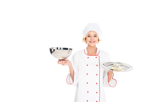 portrait of smiling female chef with empty serving tray and money looking at camera isolated on white