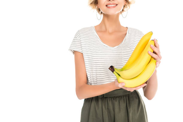 istock woman holding fresh ripe bananas isolated on white 908985500