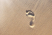 Lone footprint on sandy shore