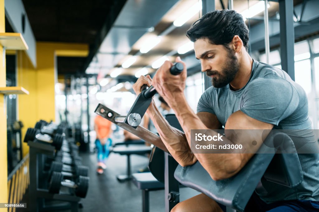 Chico musculoso culturista haciendo ejercicios - Foto de stock de Gimnasio libre de derechos