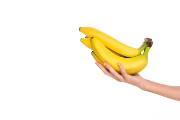 istock woman holding fresh ripe bananas isolated on white 908986132