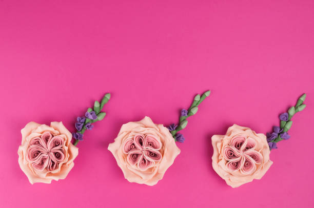 istock Pink handmade mastic flowers with green branches on pink background. 908989756
