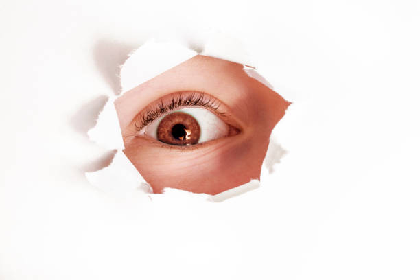 istock little girl peeking  through paper hole 908992516