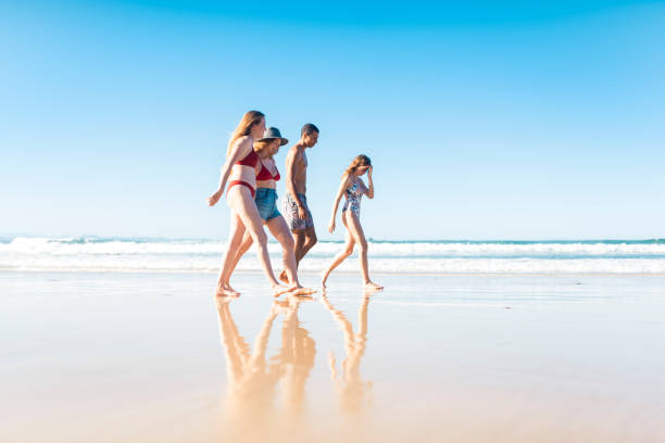 istock Friends walking on the shore near the ocean 908999942
