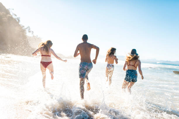 istock Friends running on the shore near the ocean 908999984