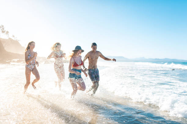 istock Group of people playing at the beach 908999996
