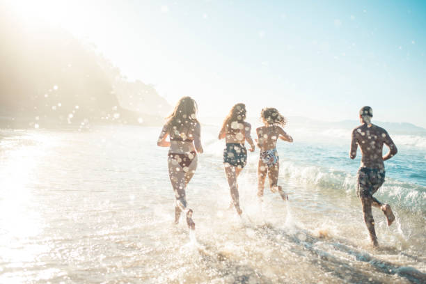 istock Friends playing and running in the ocean 909000032