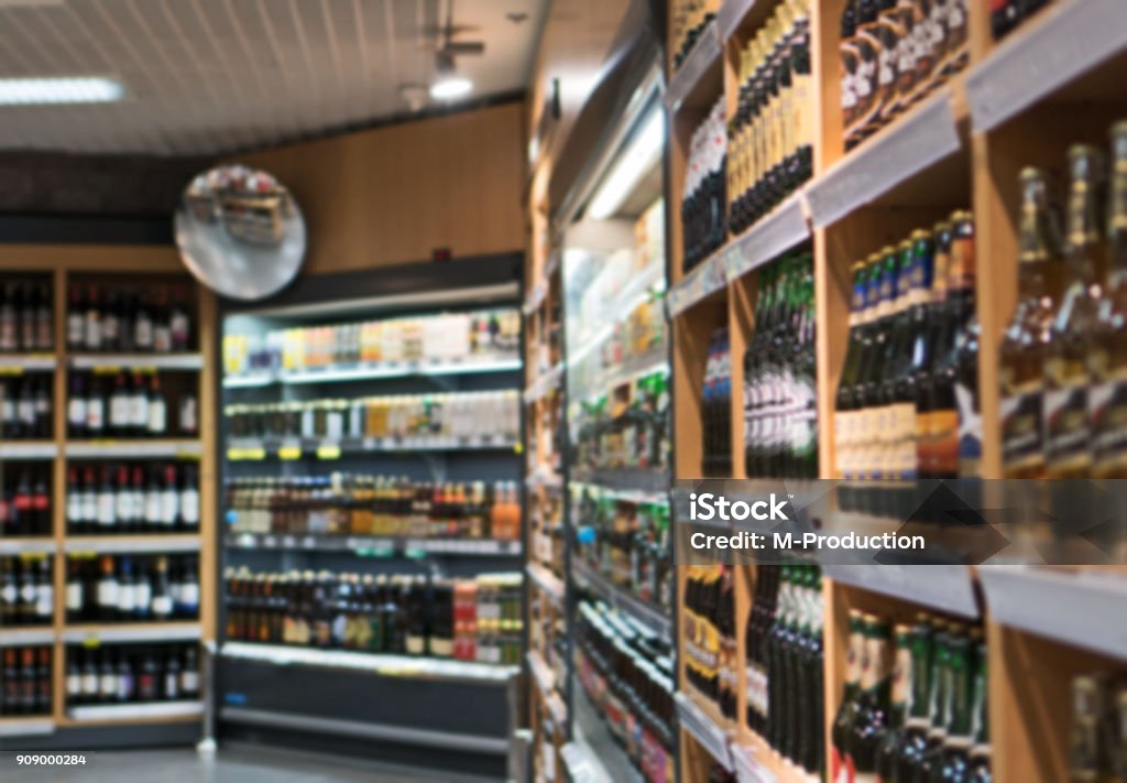 Blurred image of shelves with alcoholic drinks in supermarket. Store Stock Photo