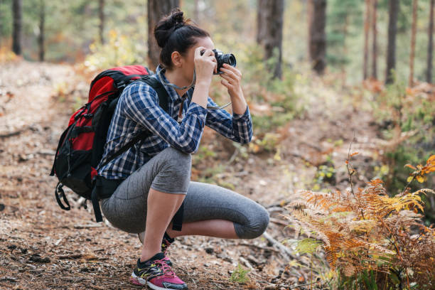 istock Woman taking pictures in the forest. 909006396