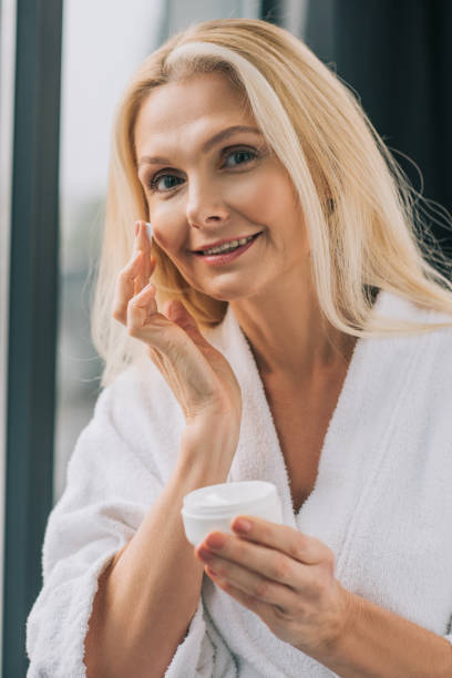istock mature woman applying cosmetic cream 909006628