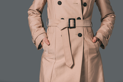 cropped shot of woman in trench coat isolated on grey