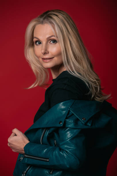 istock mature woman taking of leather jacket 909009680