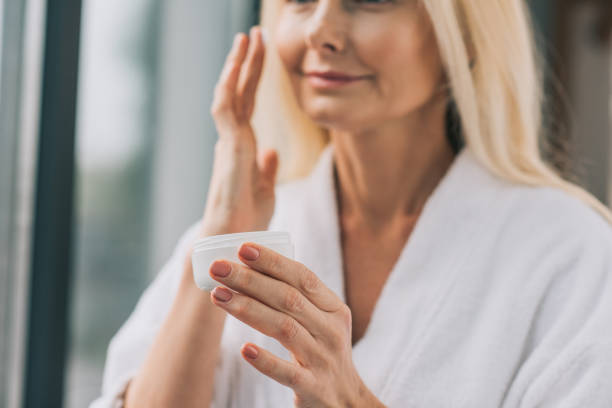 istock mature woman applying cosmetic cream 909010384