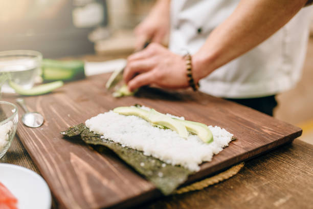 istock Male cook hands making sushi rolls, seafood 909010564
