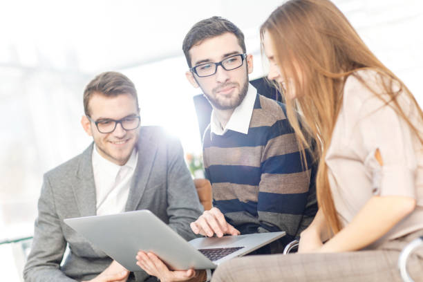 istock friendly business team working on laptop and discussing business matters 909019544