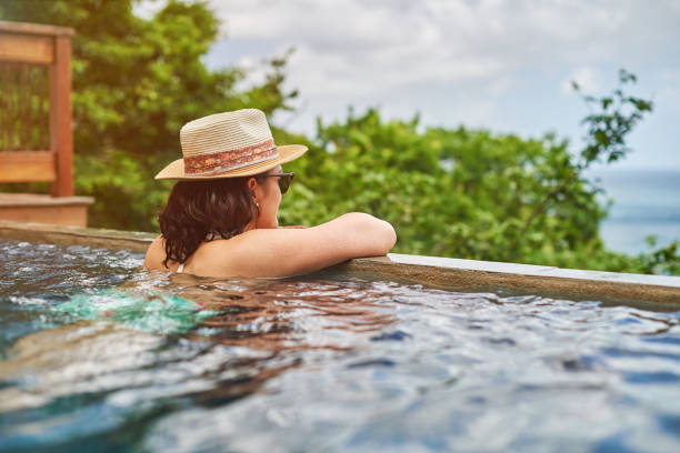istock Young woman enjoying time in pool 909023478