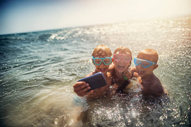 Family taking selfie on a beach in the evening
