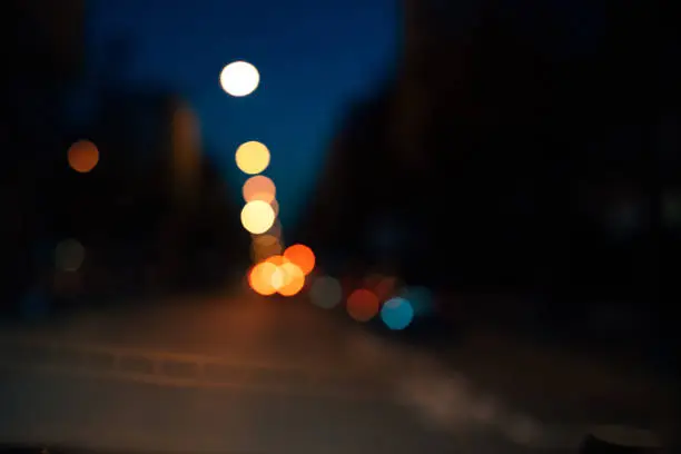 Defocused blur lights of city lights at night - pov of driver in the car