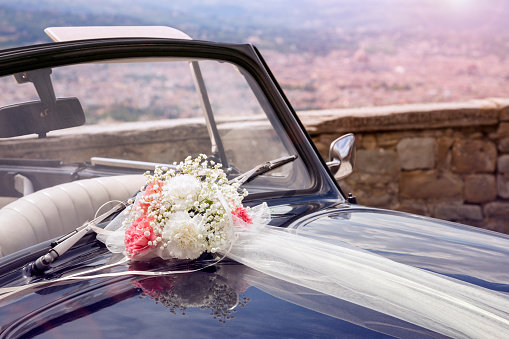 Vintage wedding car with bouquet of flowers on bonnet