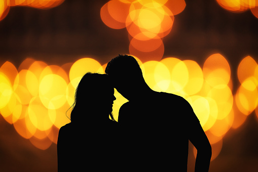 Silhouette of a couple with de-focused / bokeh lights.