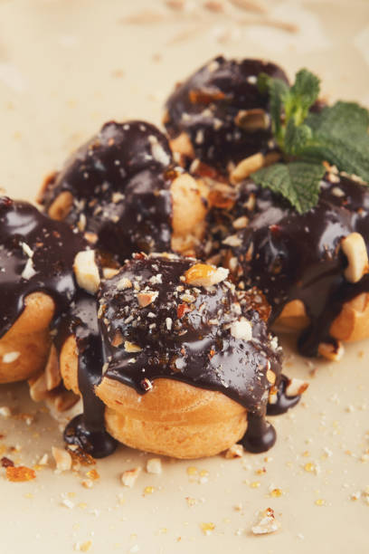 istock French profitroles with chocolate icing and mint leaves 909029974